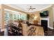 Open concept living room showcasing an elegant fireplace, a seamless flow to the office nook, and hardwood floors at 9735 Wheatfield Rd, Charlotte, NC 28277