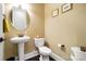 Charming powder room featuring a pedestal sink, toilet, and warm, neutral wall color at 9735 Wheatfield Rd, Charlotte, NC 28277