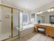 Bright bathroom with tub, shower and vanity with seating at 9923 Paradise Ridge Rd, Charlotte, NC 28277