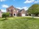 Charming brick home with manicured lawn, mature trees, and attached two car garage at 9923 Paradise Ridge Rd, Charlotte, NC 28277
