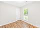 Bright bedroom with a window, door, and wood-look floors for a clean, modern look at 10200 Cairnsmore Pl # 9, Mint Hill, NC 28227
