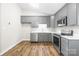 A well-lit kitchen features gray cabinets, stainless steel appliances, and bright white countertops at 10200 Cairnsmore Pl # 9, Mint Hill, NC 28227
