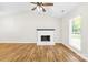 Bright living room featuring a fireplace, a ceiling fan, and wood flooring at 10200 Cairnsmore Pl # 9, Mint Hill, NC 28227