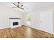 Bright living room featuring a fireplace, a ceiling fan, and wood flooring at 10200 Cairnsmore Pl # 9, Mint Hill, NC 28227