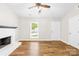 Bright living room featuring a fireplace, a ceiling fan, and wood flooring at 10200 Cairnsmore Pl # 9, Mint Hill, NC 28227