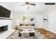 Staged living room featuring a white painted fireplace, hardwood floors, and a neutral sofa at 10200 Cairnsmore Pl # 9, Mint Hill, NC 28227
