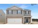 Two-story home with gray siding, blue shutters, brick accents, and a two-car garage, presenting a modern and inviting curb appeal at 1023 Hostler Ln, York, SC 29745