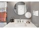 Well-lit bathroom featuring a modern vanity with a quartz countertop, round mirror and a heated towel rack at 1100 Mona Dr, Charlotte, NC 28206