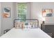 Light-filled bedroom with two windows, a dresser, and a comfortable bed with colorful decorative pillows at 1100 Mona Dr, Charlotte, NC 28206