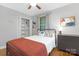 Bright bedroom with a spacious closet, a ceiling fan, a dark dresser and a cozy bed with colorful pillows at 1100 Mona Dr, Charlotte, NC 28206