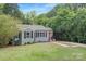 Charming home with a lush green lawn, mature trees, and a paved driveway, offering curb appeal at 1100 Mona Dr, Charlotte, NC 28206