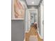Hallway with hardwood floors leads to a bedroom, featuring modern decor and neutral color palette at 1100 Mona Dr, Charlotte, NC 28206