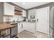 Bright kitchen featuring stainless steel appliances, white cabinetry, granite countertops, and a breakfast bar at 1100 Mona Dr, Charlotte, NC 28206