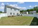 Spacious backyard featuring a well-maintained lawn, a stone fire pit, and a white privacy fence at 1180 Bannockburn Ave, Rock Hill, SC 29732