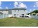 Expansive backyard with a lush green lawn, fenced perimeter, patio, and fire pit at 1180 Bannockburn Ave, Rock Hill, SC 29732