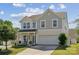 Charming two-story home featuring a covered front porch and an attached two-car garage on a sunny day at 1180 Bannockburn Ave, Rock Hill, SC 29732