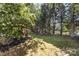 Spacious backyard featuring mature trees, a swing, a hammock, and a covered patio area at 11807 Hawick Valley Ln, Charlotte, NC 28277