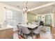 Elegant dining area featuring a modern table, chandelier, and large windows for natural light at 11807 Hawick Valley Ln, Charlotte, NC 28277