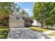 Beautifully landscaped front yard with mature trees and a spacious driveway leading to a two-car garage at 11807 Hawick Valley Ln, Charlotte, NC 28277