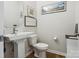 This half bathroom features a pedestal sink, wood floors, and decorative nautical themed wall art at 119 Berkeley Ave # A, Mooresville, NC 28117