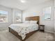 Spacious bedroom boasts a wooden bed frame, carpet flooring, and two sunny windows at 119 Berkeley Ave # A, Mooresville, NC 28117