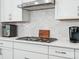 Close-up of the kitchen cooktop highlighting modern appliances and stylish hexagonal backsplash at 119 Berkeley Ave # A, Mooresville, NC 28117
