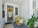 Cozy front porch featuring stylish yellow seating, a welcoming mat, and a cheerful sunflower wreath at 119 Berkeley Ave # A, Mooresville, NC 28117