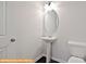 Half bathroom features a pedestal sink, oval mirror, and modern lighting fixture at 6320 Busch Way, Midland, NC 28107