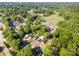 Aerial view showcases the neighborhood, including residential streets and power lines surrounded by lush greenery at 1211 N Boyce St, Gastonia, NC 28052
