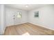Bright bedroom featuring new laminate flooring, two windows, and a door at 1211 N Boyce St, Gastonia, NC 28052