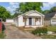 Charming white brick home with a cozy front porch and driveway on the side at 1211 N Boyce St, Gastonia, NC 28052