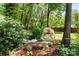 Backyard garden space featuring a stone bench, mature trees and landscaping at 1261 Hawthorne Dr, Indian Trail, NC 28079