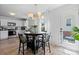 Open dining area with adjacent kitchen and a stylish light fixture above a black circular table at 1925 Maius Dr # 30, Conover, NC 28613
