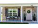 Inviting front porch with seating, features a pink door adorned with a wreath and decorative plants at 1925 Maius Dr # 30, Conover, NC 28613