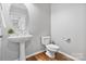 Charming powder room features a pedestal sink, round mirror, and modern fixtures at 1929 Faison Ave, Fort Mill, SC 29708