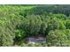 Overhead shot of a tree-shrouded property, a home address is visible on the driveway at 1956 Forest Ridge Dr, Stanley, NC 28164