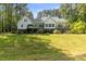 White home with large backyard and a black fence offers an appealing exterior view of the property at 1956 Forest Ridge Dr, Stanley, NC 28164