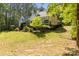 Large, grassy backyard featuring a white home with covered porch, a fenced in area, and wooded perimeter at 1956 Forest Ridge Dr, Stanley, NC 28164