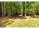 A secluded backyard with mature trees offers a private outdoor escape at 1956 Forest Ridge Dr, Stanley, NC 28164