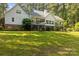 Spacious backyard featuring a white home with deck, garden area, and wooded surroundings for privacy at 1956 Forest Ridge Dr, Stanley, NC 28164