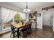 Bright dining room with wooden table, chairs, and sheer curtains letting in natural light from the windows at 1956 Forest Ridge Dr, Stanley, NC 28164