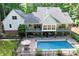 A grand home with a multi-level deck, in-ground pool, hot tub, and surrounded by mature trees at 1956 Forest Ridge Dr, Stanley, NC 28164