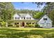 Charming two-story white home features a welcoming front porch and lush landscaping at 1956 Forest Ridge Dr, Stanley, NC 28164