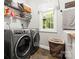 Functional laundry room featuring a washer, dryer, shelving, and a utility sink with a window at 1956 Forest Ridge Dr, Stanley, NC 28164