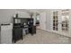 Well-lit office with a black desk, printer, and French doors leading to other areas of the home at 1956 Forest Ridge Dr, Stanley, NC 28164