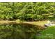 Pond with deck, sitting area, and shady trees offer an attractive view from the rear of the home at 1956 Forest Ridge Dr, Stanley, NC 28164