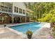 Backyard pool with a brick deck area surrounded by lush greenery and trees at 1956 Forest Ridge Dr, Stanley, NC 28164