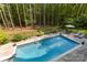 Aerial view of a sparkling backyard pool with diving board, surrounded by lush greenery and a privacy fence at 1956 Forest Ridge Dr, Stanley, NC 28164