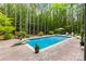 Sparkling in-ground pool with a diving board and an expansive patio surrounded by lush greenery and privacy fence at 1956 Forest Ridge Dr, Stanley, NC 28164