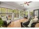 Bright sunroom with wicker furniture, tile flooring, ceiling fan, and multiple windows overlooking greenery at 1956 Forest Ridge Dr, Stanley, NC 28164